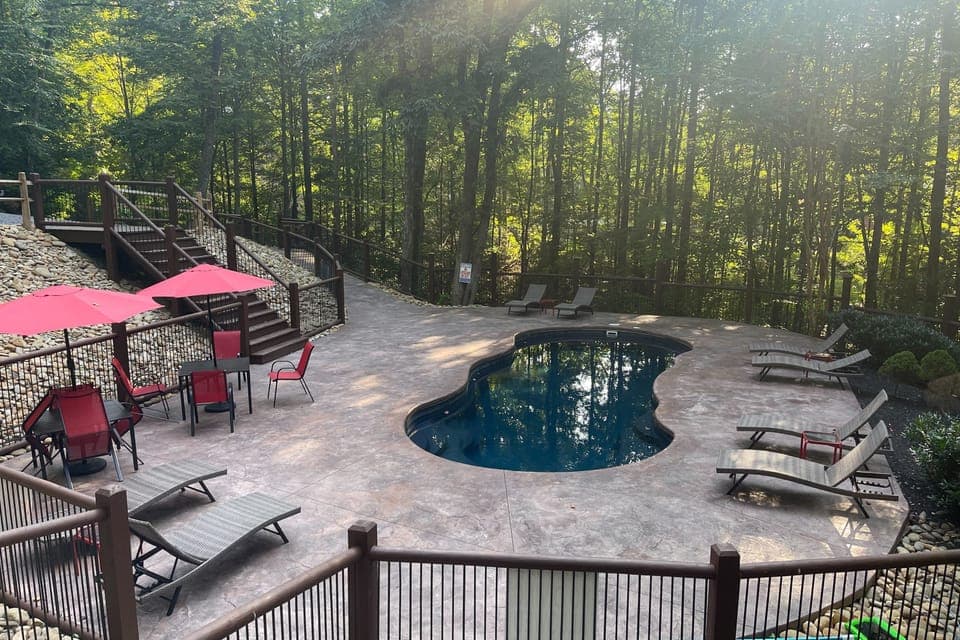 Beautiful community pool surrounded by trees.