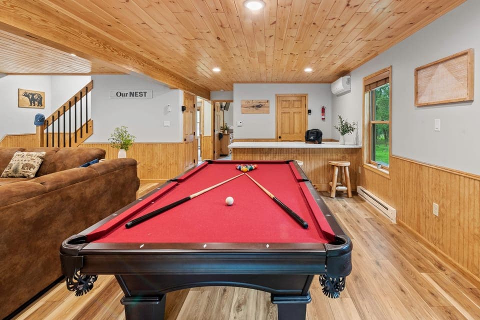The second living area offers a pool table, a TV,  and a bar counter.