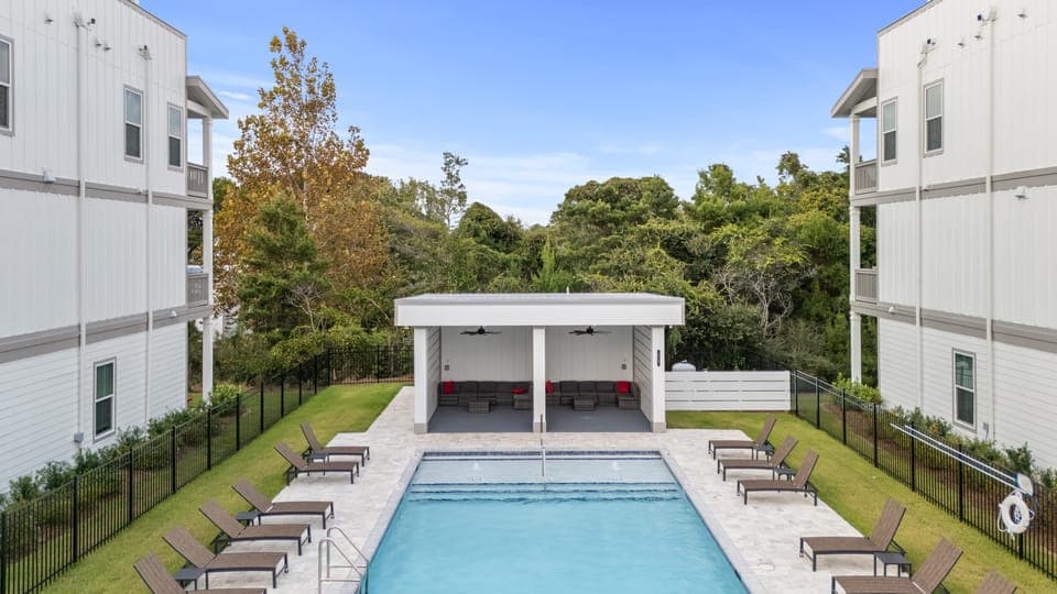 Resort-style community pool with loungers and shaded cabanas—perfect for sunny days and laid-back afternoons.