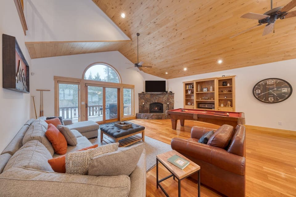Large living area with a pool table and fireplace.