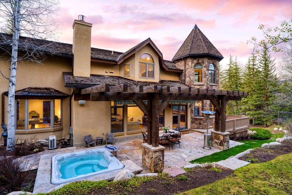 Backyard with a hot tub and outdoor dining table.