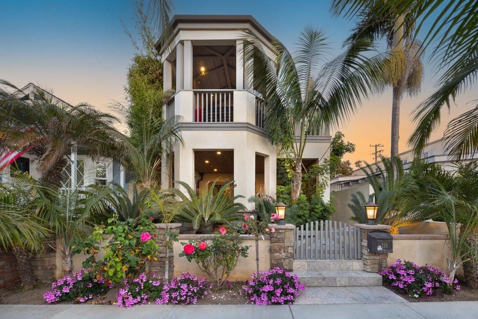A picture-perfect exterior with lush palms and a golden sky.