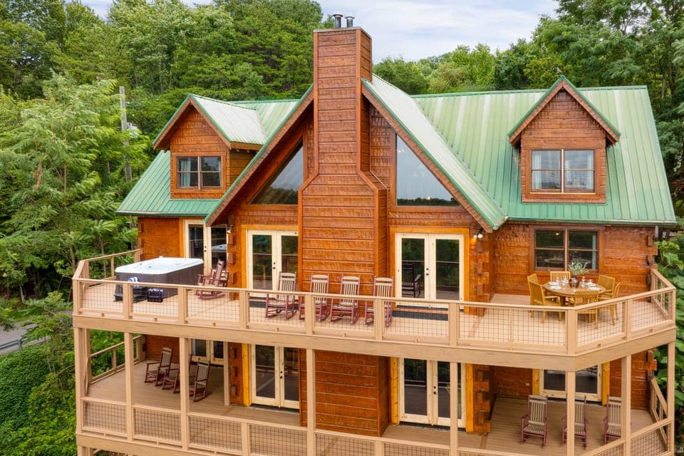 Spacious exterior with several furnished decks and a hot tub for ultimate comfort.