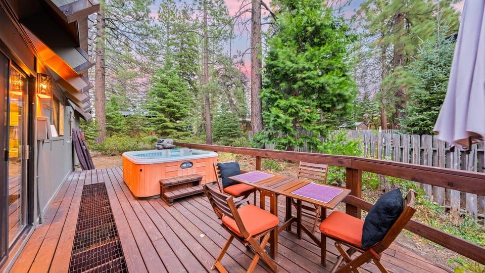 Spacious outdoor deck with comfortable lounge seating and a hot tub.