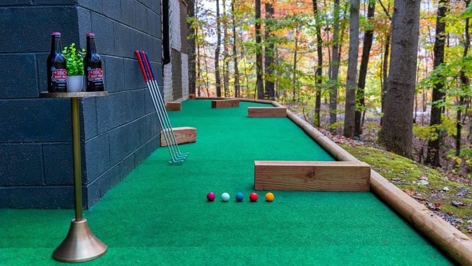The backyard of our cabin has something for everyone—mini-golf, cornhole, and more for endless fun!