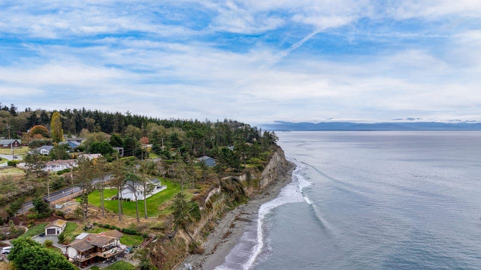 Bright living room with a TV, floor-to-ceiling windows, and ocean view.