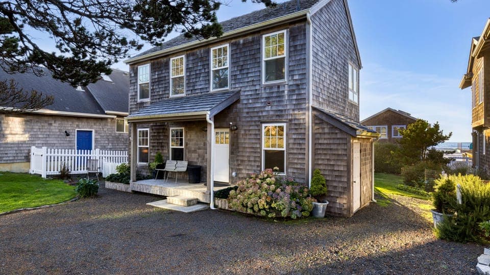 Enjoy the beautiful exterior and inviting front porch of this classic beach home, perfectly nestled on the coast.