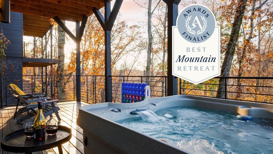 Modern living room featuring a high ceiling, multiple windows, a TV, and a fireplace.