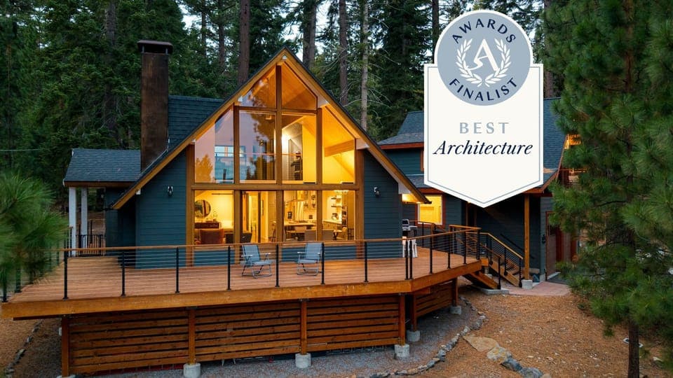 Cozy living room with soaring windows, forest views, and a wood-burning stove for perfect Tahoe nights.