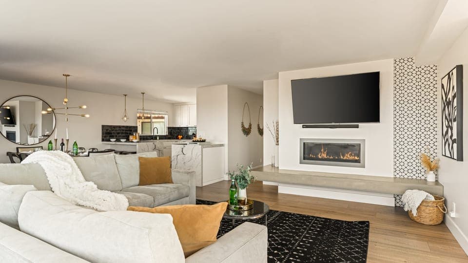 Bright and inviting living area featuring a sleek fireplace, open layout, and seamless flow into the designer kitchen.