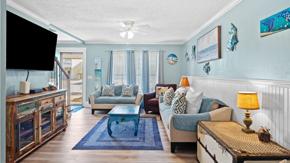 Bright living room with mounted TV and coastal decor.