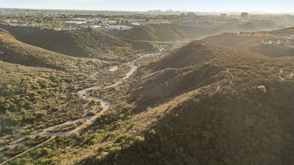 Wide aerial view of the vast canyon and rolling hills surrounding the community.