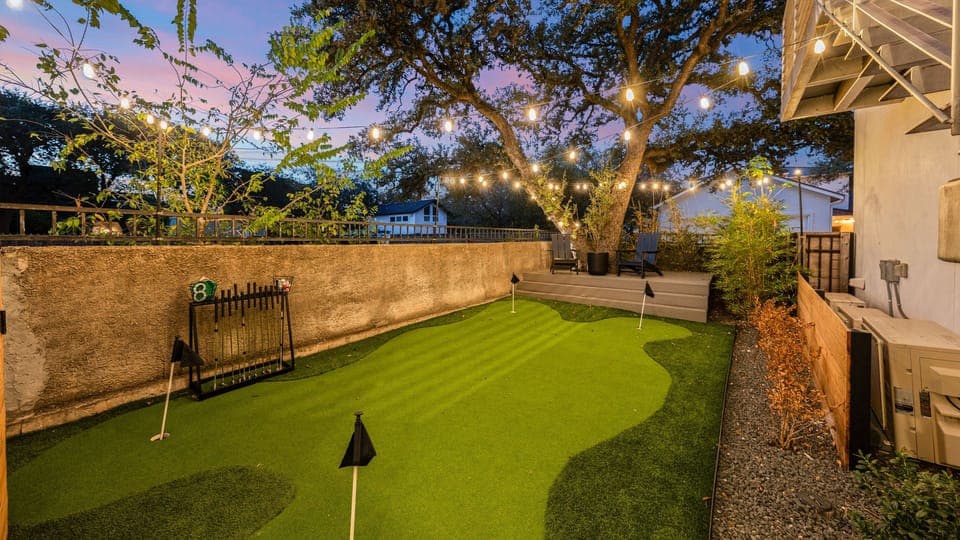 Enjoy the shared putting green under glowing string lights for a relaxing evening activity.