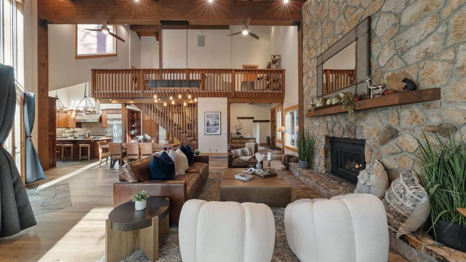 Gather in this stunning great room, where soaring beams, a stone fireplace, and cozy textures set the scene for unforgettable Tahoe moments.