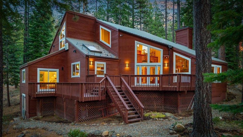 Warm cabin light meets towering pines—your perfect Tahoe retreat awaits.