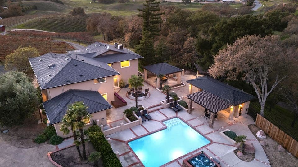 Evening aerial view of the main residence and pool.