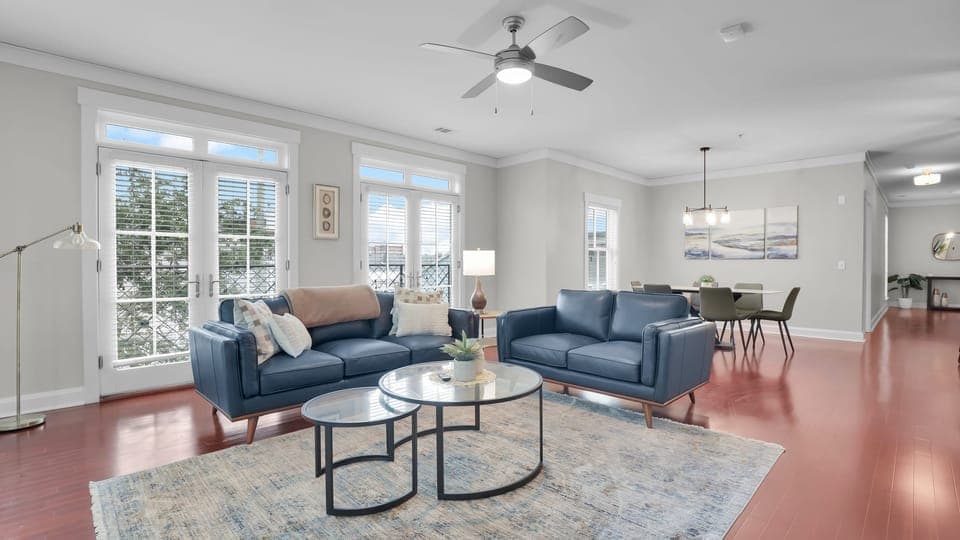 Spacious open living and dining area with modern décor, large windows, and natural light.