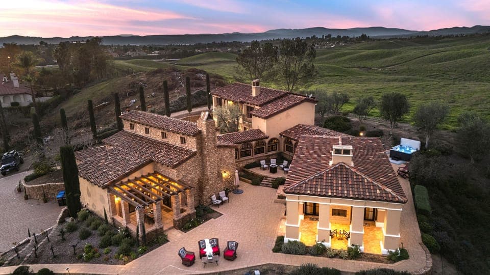 An illuminated estate set against rolling Temecula hills—where vineyard views and sunset skies set the tone for unforgettable evenings.