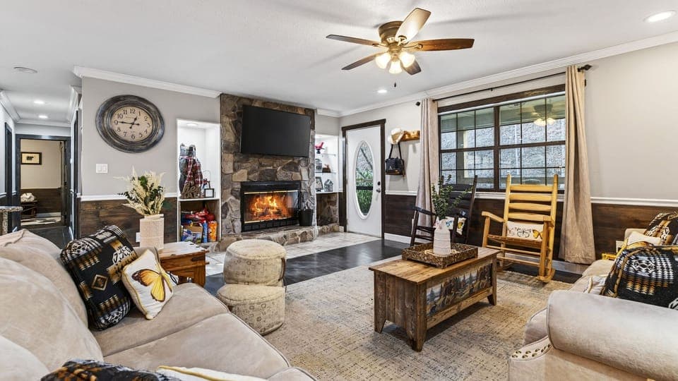 Warm up indoors in this inviting living room, where a stone fireplace, plush seating, and rustic details set the tone for cozy mountain nights.