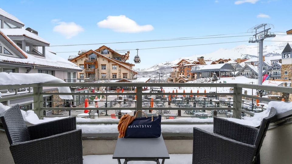 Scenic balcony view of the snowy mountain village and ski lifts.