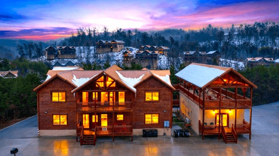 Golden-hour mountain retreat glowing at dusk, with expansive decks, cozy cabin charm, and sweeping Smoky Mountain views in every direction.