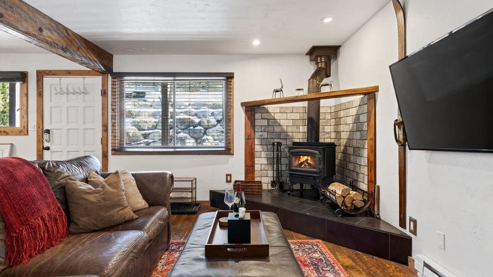 Cozy living room with a wood-burning stove, plush leather seating, and a big-screen TV—perfect for après-ski nights.