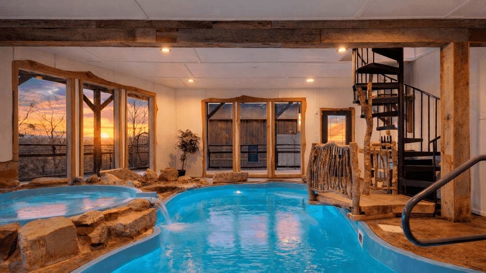 Private indoor pool with a hot tub, waterfall features, and space to unwind year-round. (Aspen Lodge)