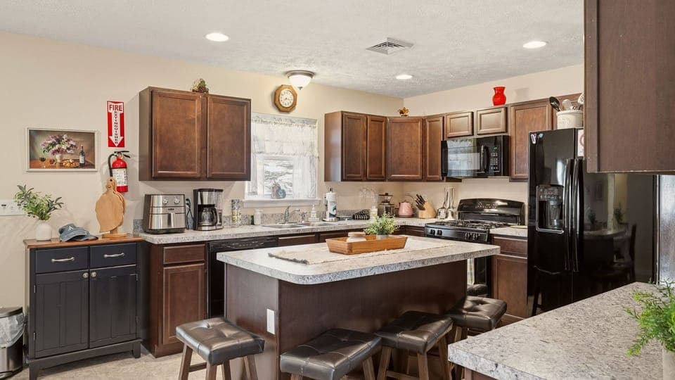 Cozy, well‑equipped kitchen with granite counters, stainless steel appliances, and a spacious island for gathering.