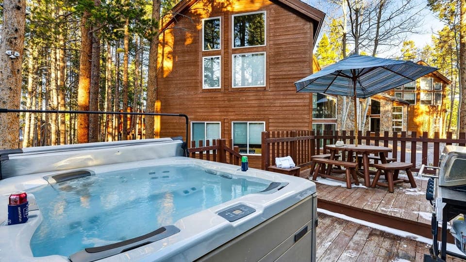 Back deck view featuring a relaxing hot tub and outdoor dining area.