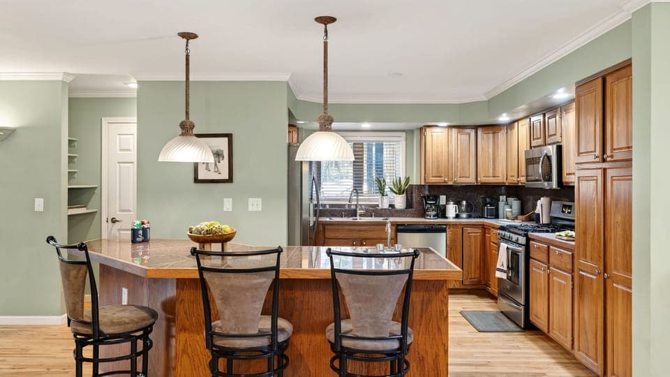 Spacious kitchen with barstool seating and modern appliances.