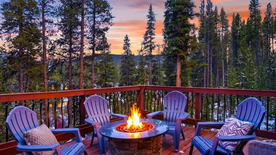 Fire pit deck with Adirondack seating and stunning sunset views over the forest.