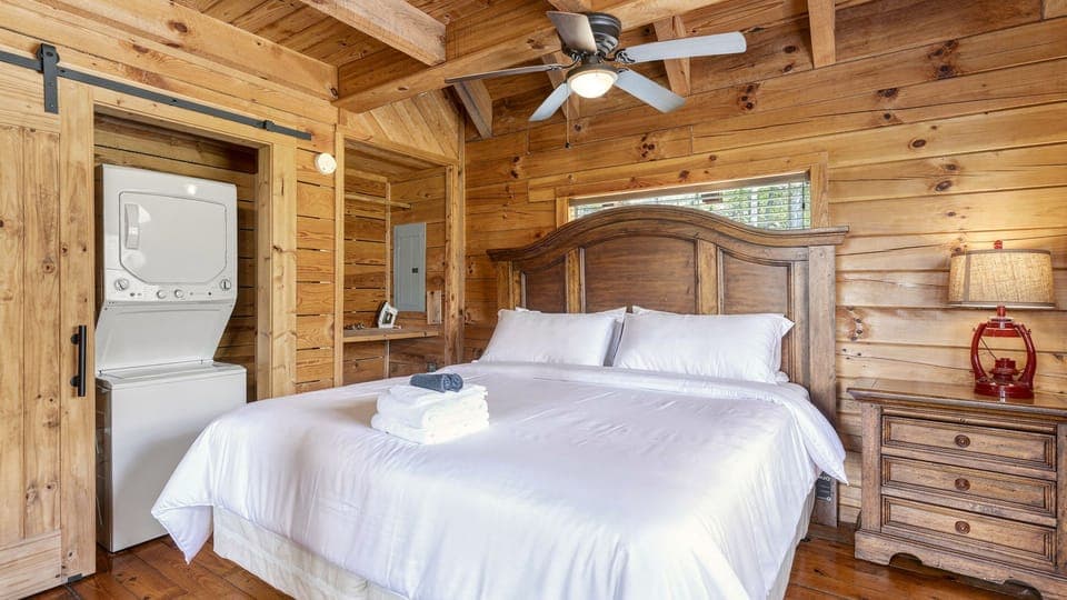 Warm wood‑paneled cabin dining room with a rustic table, mountain views through large windows, and soft natural light filling the space.