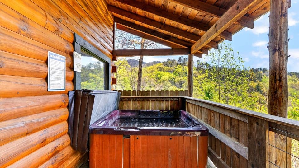 Warm cabin living room with a stone fireplace, cozy seating, and big windows opening to peaceful mountain views.