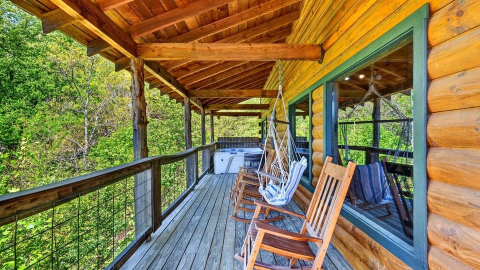 Covered wraparound deck with rocking chairs and a hanging swing—perfect for slow mornings and mountain air.