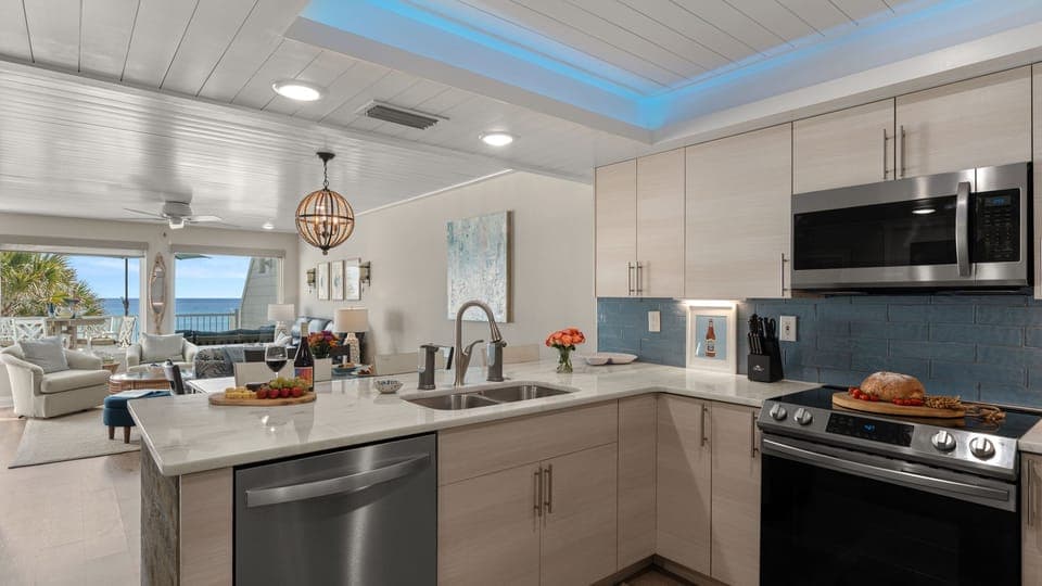 Fully equipped kitchen featuring a deep stainless steel sink, dishwasher, and more.