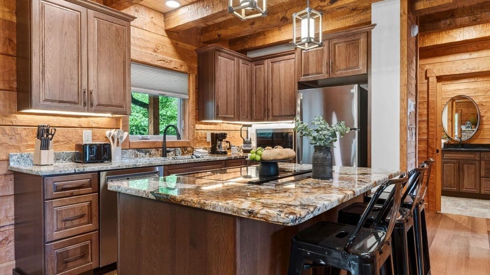 Chef’s kitchen with granite countertops, stainless steel appliances, and island seating.