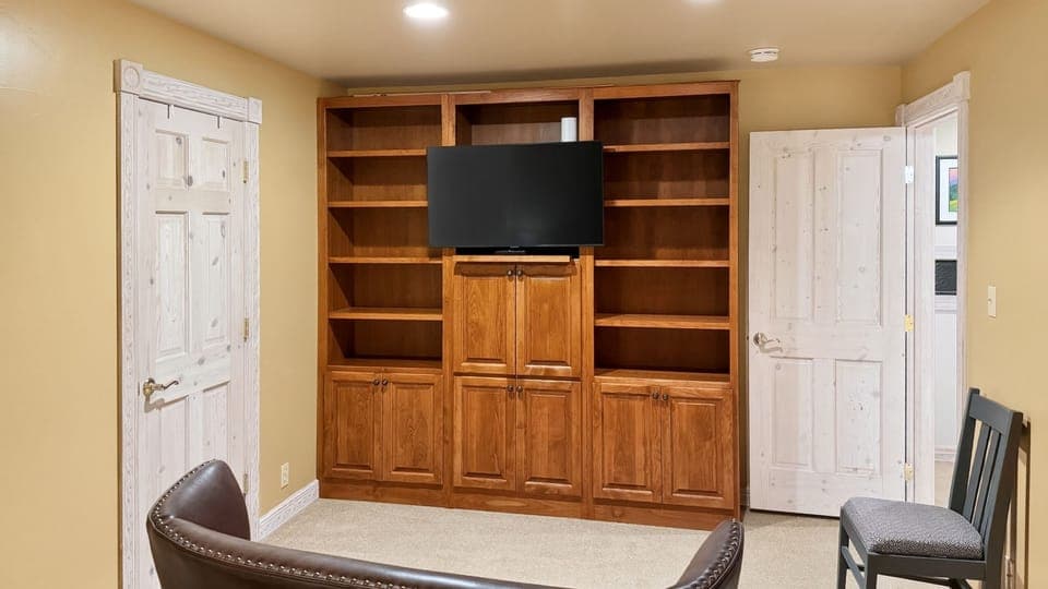 Quiet TV nook with built-in shelving, perfect for a relaxed movie night or a cozy break between adventures.