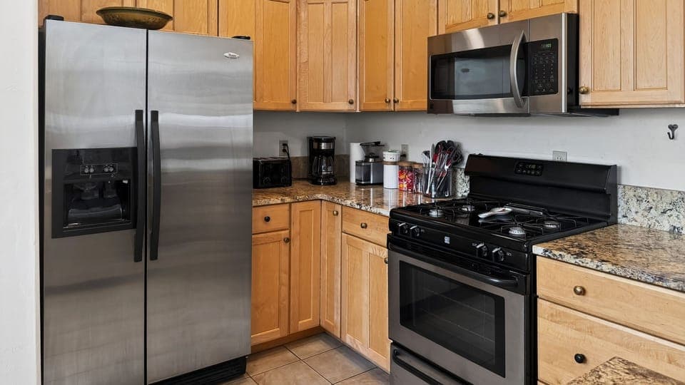 Fully equipped kitchen with stainless steel appliances, granite counters, and everything needed for easy meals at home.