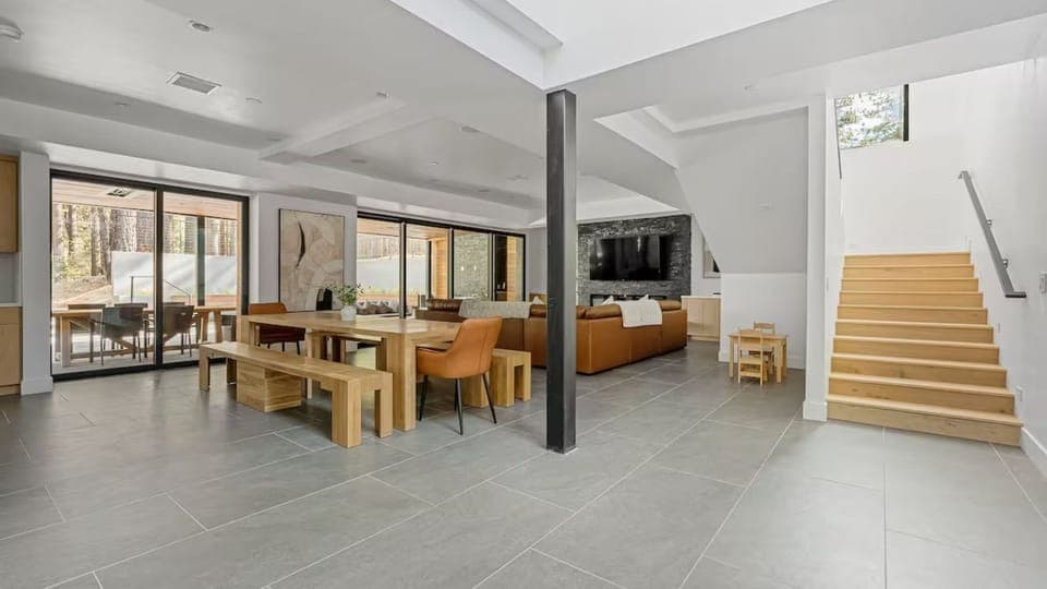 Seamless flow between the living, dining, and kitchen areas, anchored by modern architectural elements.