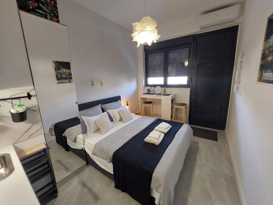 Bed, Seating area, Text overlay, towels, air conditioner