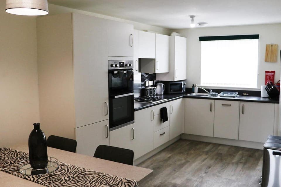 Kitchen or kitchenette, dishwasher, microwave, oven, stove, toaster, towels, washing machine, washing machine, kitchen