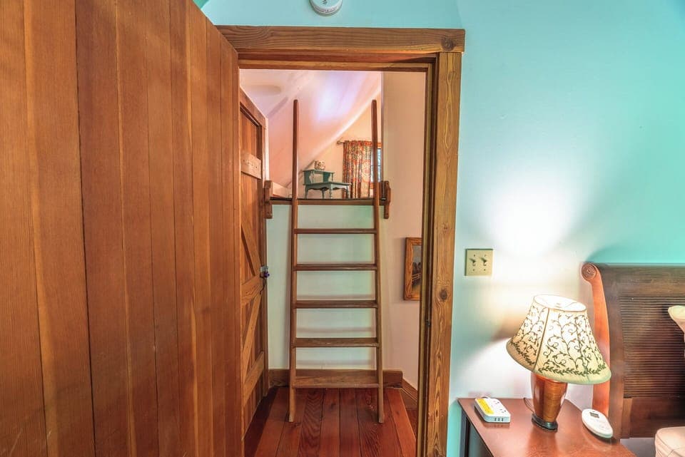 The reading loft is up this small ladder, across from - the primary bedroom.