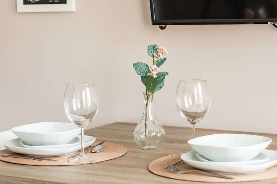 A close-up of a dining table set for two with wine glasses and decorative elements.


