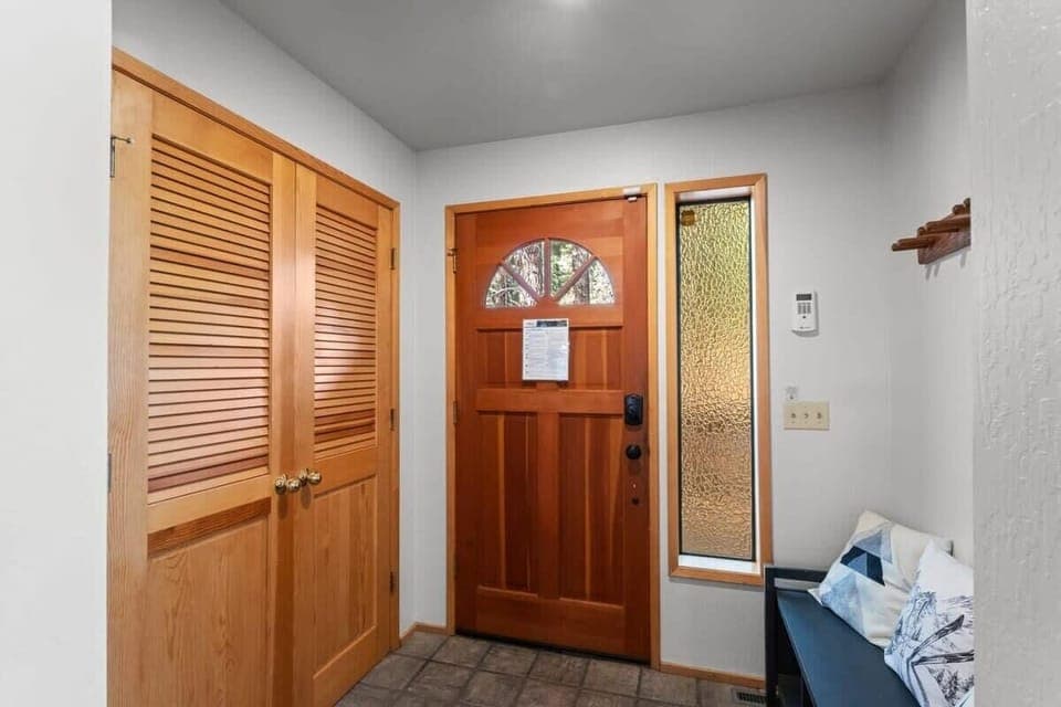 A front hallway provides a comfortable space to unload your outdoor gear with a bench, coat hooks, and a storage closet.