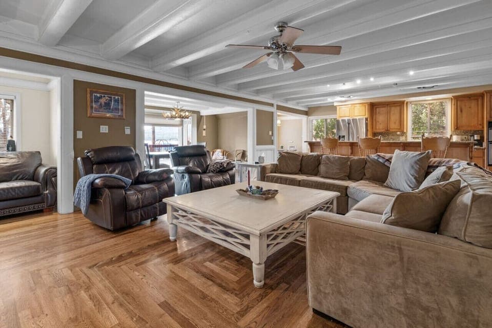 Open living room w/ plush seating & exposed beams, ideal for relaxing together after a full day.