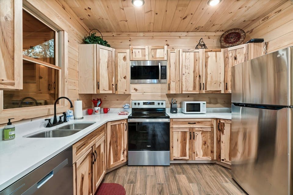 This modern kitchen in a pet-friendly Sevierville cabin features stainless steel appliances, rustic wood cabinets, and sleek counters. Fully equipped for cooking, it's great for a cozy getaway.