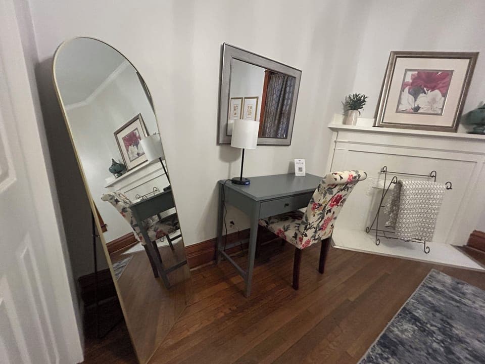 Primary bedroom features dedicated workspace and full length mirror.