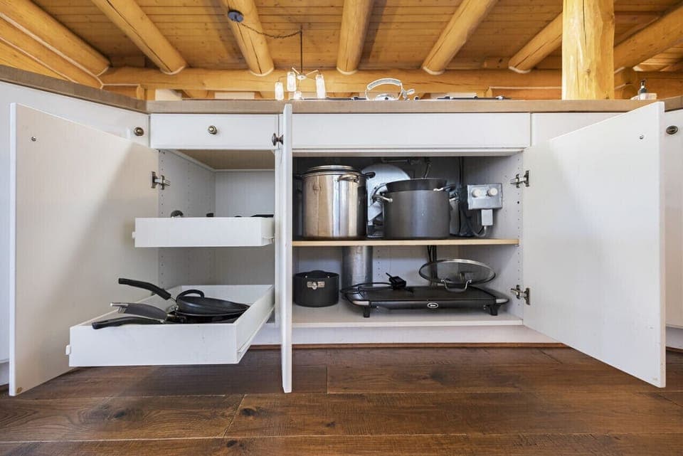 Fully stocked kitchen cabinets with cookware and essentials