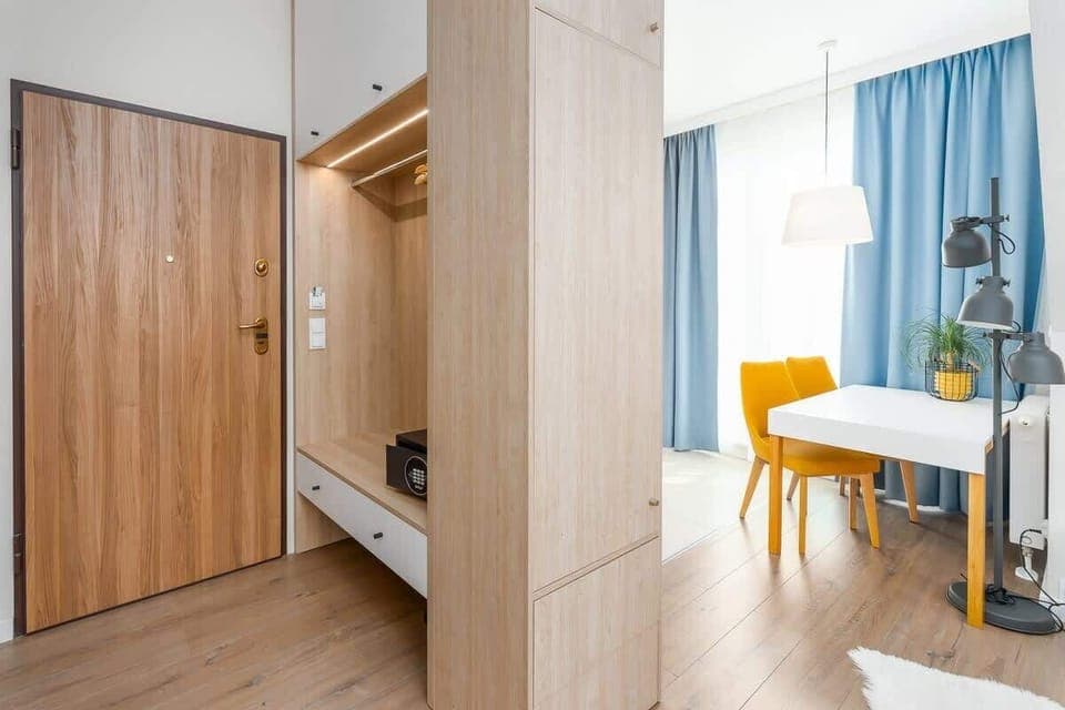A hallway with wooden storage cabinets, leading to the main living area, featuring clean and modern design.

