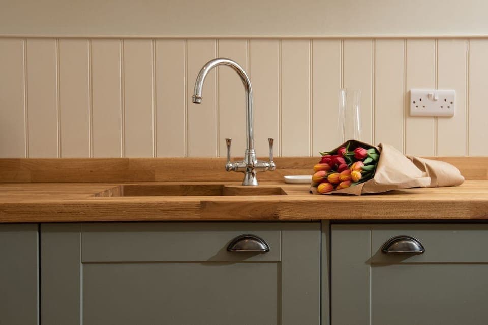 The Trouthouse - solid wood worktop and undermounted sink with characterful wall panelling above